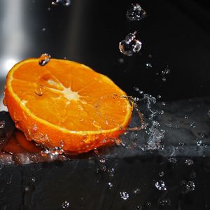 Превью обои апельсин, долька, брызги, вода