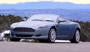 Превью обои астон мартин, 2004, голубой, вид спереди, стиль, aston martin, db9, авто, природа, горы, деревья