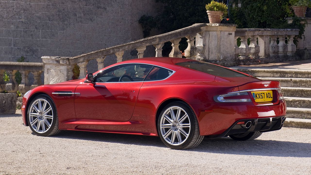 Скачать 1280x720 астон мартин, 2008, красный, вид сбоку, стиль, aston  martin, dbs, дом, кустарники обои, картинки hd, hdv, 720p