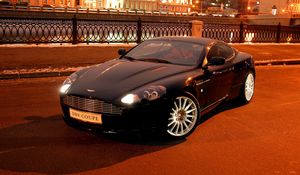 Превью обои aston martin, db9, 2004, черный, вид спереди, стиль, авто, астон мартин, город, дома, огни, асфальт