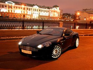 Превью обои aston martin, db9, 2004, черный, вид спереди, стиль, авто, астон мартин, город, дома, огни, асфальт