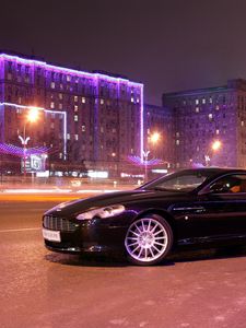 Превью обои aston martin, db9, 2004, черный, вид сбоку, стиль, авто, астон мартин, дома, огни, город, асфальт