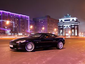 Превью обои aston martin, db9, 2004, черный, вид сбоку, стиль, авто, астон мартин, дома, огни, город, асфальт