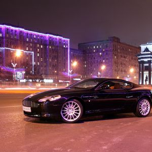 Превью обои aston martin, db9, 2004, черный, вид сбоку, стиль, авто, астон мартин, дома, огни, город, асфальт