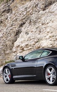 Превью обои aston martin, db9, 2006, черный, вид сбоку, стиль, астон мартин, авто, спорт, скала