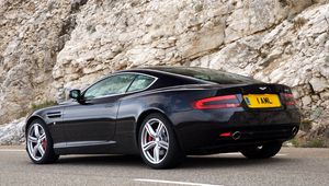 Превью обои aston martin, db9, 2006, черный, вид сбоку, стиль, астон мартин, авто, спорт, скала