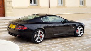 Превью обои aston martin, db9, 2006, черный, вид сбоку, стиль, авто, астон мартин, спорт, здание