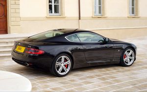 Превью обои aston martin, db9, 2006, черный, вид сбоку, стиль, авто, астон мартин, спорт, здание