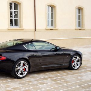 Превью обои aston martin, db9, 2006, черный, вид сбоку, стиль, авто, астон мартин, спорт, здание