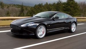 Превью обои aston martin, db9, 2006, черный, вид сбоку, стиль, спорт, астон мартин, авто, скорость, деревья, асфальт