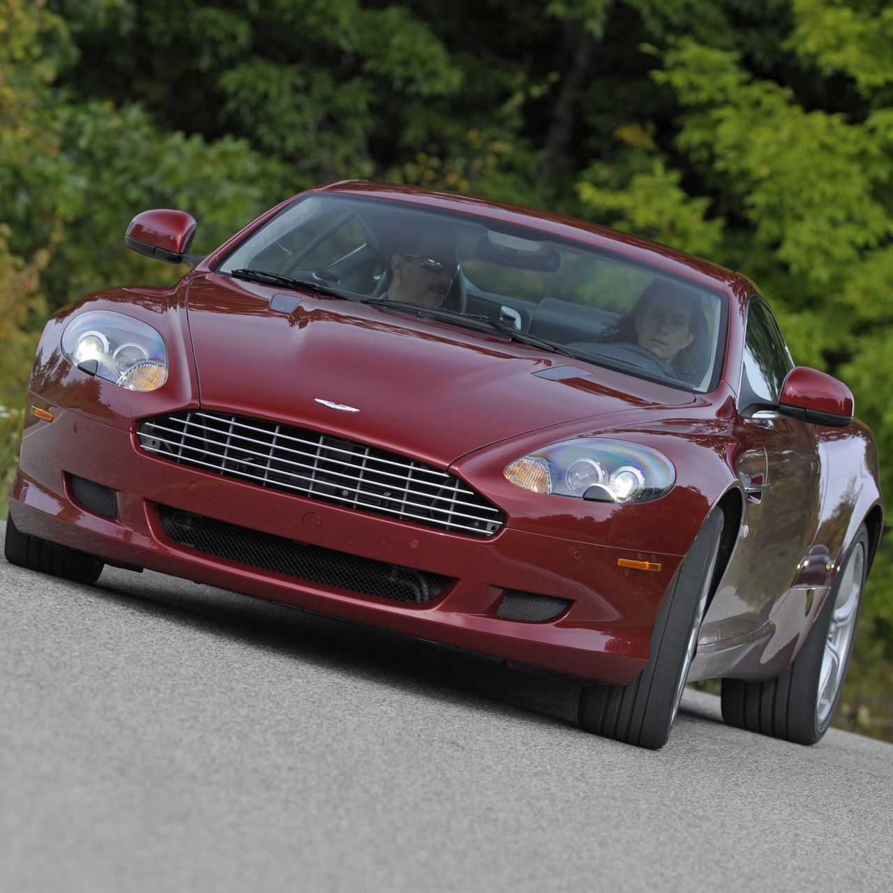 Скачать 1280x1280 aston martin db9, 2008, красный, вид спереди, стиль, авто,  астон мартин, природа, деревья, трава, знак обои, картинки ipad, ipad 2,  ipad mini for parallax