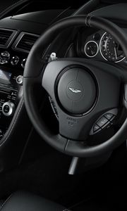 Превью обои aston martin, db9, 2010, черный, салон, интерьер, руль, спидометр