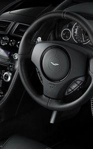 Превью обои aston martin, db9, 2010, черный, салон, интерьер, руль, спидометр