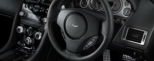 Превью обои aston martin, db9, 2010, черный, салон, интерьер, руль, спидометр