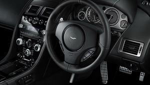 Превью обои aston martin, db9, 2010, черный, салон, интерьер, руль, спидометр