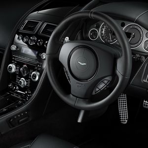 Превью обои aston martin, db9, 2010, черный, салон, интерьер, руль, спидометр