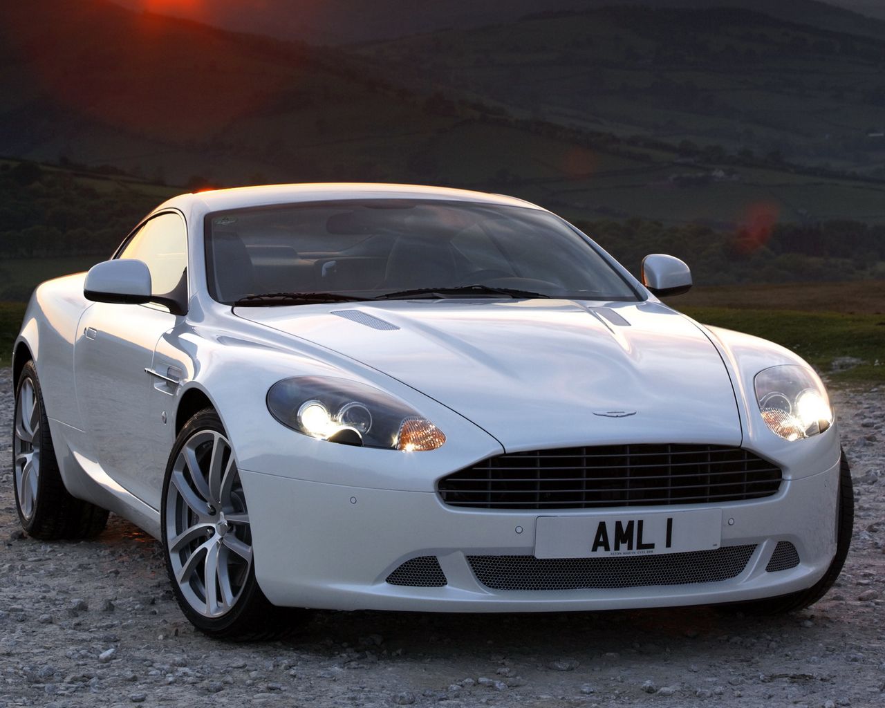 Скачать 1280x1024 aston martin, db9, 2010, белый, вид спереди, стиль,  спорт, астон мартин, авто, природа, закат, деревья, трава обои, картинки  стандарт 5:4