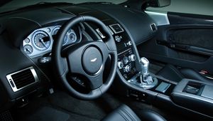 Превью обои aston martin, dbs, 2008, черный, салон, интерьер, руль, спидометр