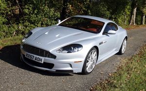 Превью обои aston martin dbs, 2008, белый, вид спереди, трава, астон мартин, деревья