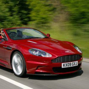 Превью обои aston martin, dbs, 2009, красный, вид сбоку, скорость, астон мартин, деревья, авто