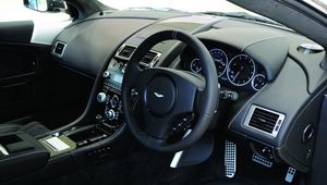 Превью обои aston martin, dbs, 2010, черный, салон, интерьер, руль, спидометр