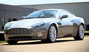 Превью обои aston martin, v12, vanquish, 2001, серый, вид сбоку, стиль, астон мартин, здание