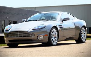 Превью обои aston martin, v12, vanquish, 2001, серый, вид сбоку, стиль, астон мартин, здание