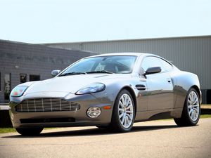 Превью обои aston martin, v12, vanquish, 2001, серый, вид сбоку, стиль, астон мартин, здание