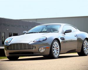 Превью обои aston martin, v12, vanquish, 2001, серый, вид сбоку, стиль, астон мартин, здание