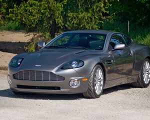 Превью обои aston martin, v12, vanquish, 2001, серый, вид спереди, астон мартин, трава