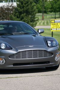 Превью обои aston martin, v12, vanquish, 2001, серый, вид спереди, астон мартин, деревья