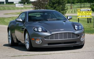 Превью обои aston martin, v12, vanquish, 2001, серый, вид спереди, астон мартин, деревья