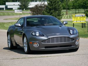 Превью обои aston martin, v12, vanquish, 2001, серый, вид спереди, астон мартин, деревья