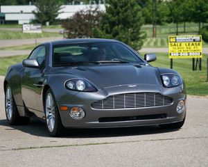 Превью обои aston martin, v12, vanquish, 2001, серый, вид спереди, астон мартин, деревья