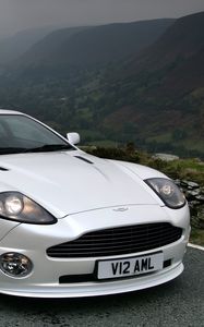 Превью обои aston martin, v12, vanquish, 2004, белый, вид спереди, авто, астон мартин, горы