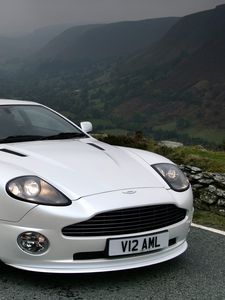 Превью обои aston martin, v12, vanquish, 2004, белый, вид спереди, авто, астон мартин, горы