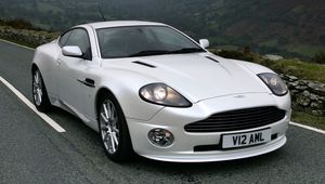 Превью обои aston martin, v12, vanquish, 2004, белый, вид спереди, авто, астон мартин, горы