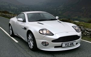 Превью обои aston martin, v12, vanquish, 2004, белый, вид спереди, авто, астон мартин, горы