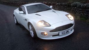 Превью обои aston martin, v12, vanquish, 2004, белый, вид спереди, астон мартин, природа