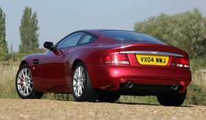 Превью обои aston martin, v12, vanquish, 2004, красный, вид сзади, стиль, астон мартин, природа