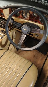 Превью обои aston martin, v8, volante, 1977, бежевый, салон, интерьер, руль, спидометр