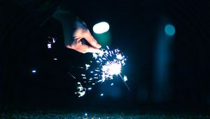 Превью обои бенгальский огонь, искры, рука, темный, темнота