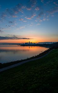 Превью обои берег, вода, горизонт, здания, закат, темный