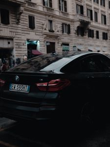 Превью обои bmw, черный, вид сзади, город