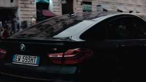 Превью обои bmw, черный, вид сзади, город