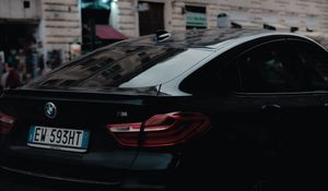 Превью обои bmw, черный, вид сзади, город
