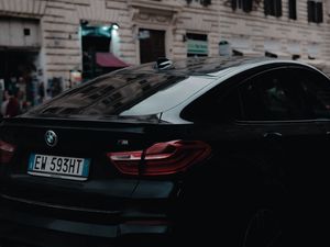 Превью обои bmw, черный, вид сзади, город