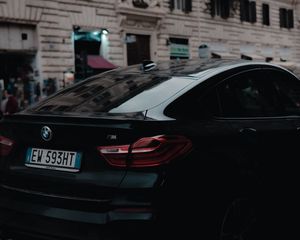 Превью обои bmw, черный, вид сзади, город