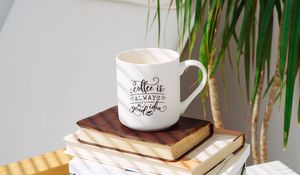 Превью обои чашка, надпись, книги, растение, тень