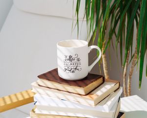 Превью обои чашка, надпись, книги, растение, тень